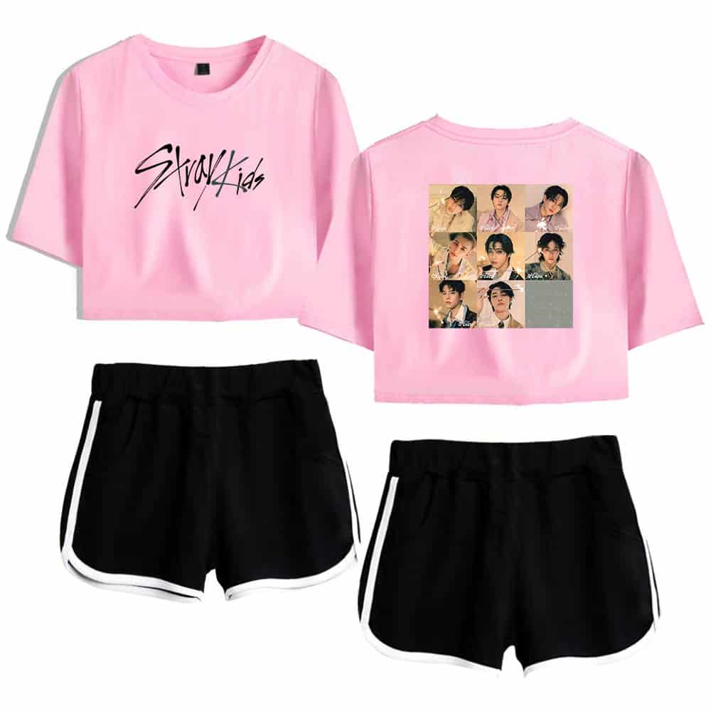 Pink K-pop merch crop top with 'Stray Kids' logo and group photo on the back, paired with black athletic shorts with white trim.